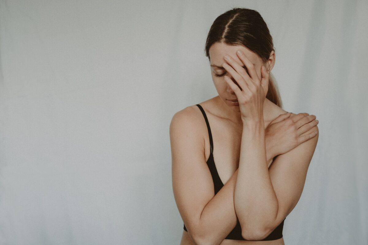 A woman in contemplation with a hand on her face, expressing emotional distress