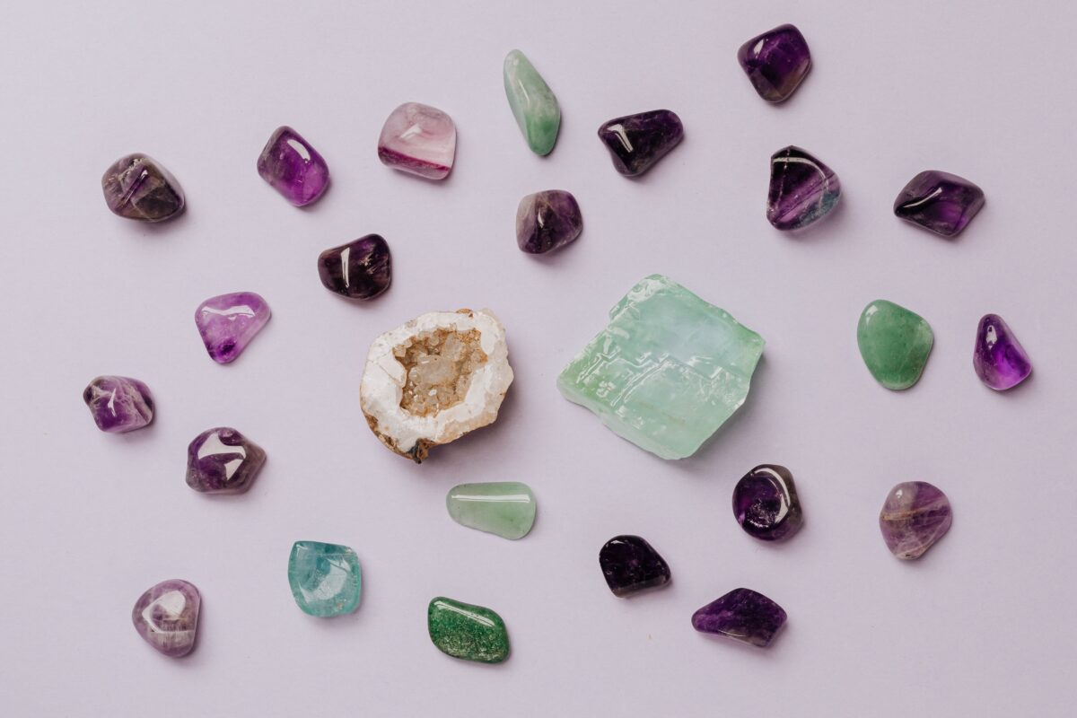 Flat lay of assorted polished gemstones including amethyst and jade