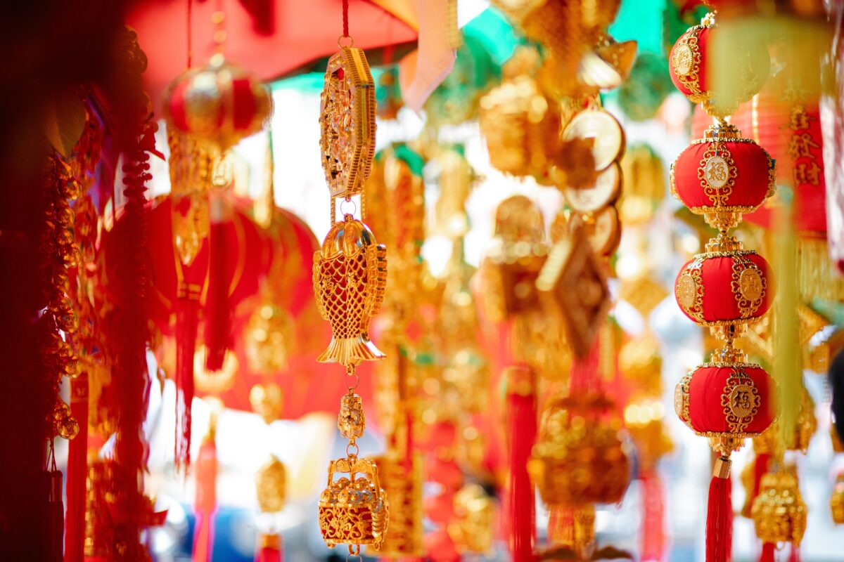 Traditional red and gold Feng Shui good luck charms, lanterns, and golden fish ornaments hanging to attract positive energy into a home.
