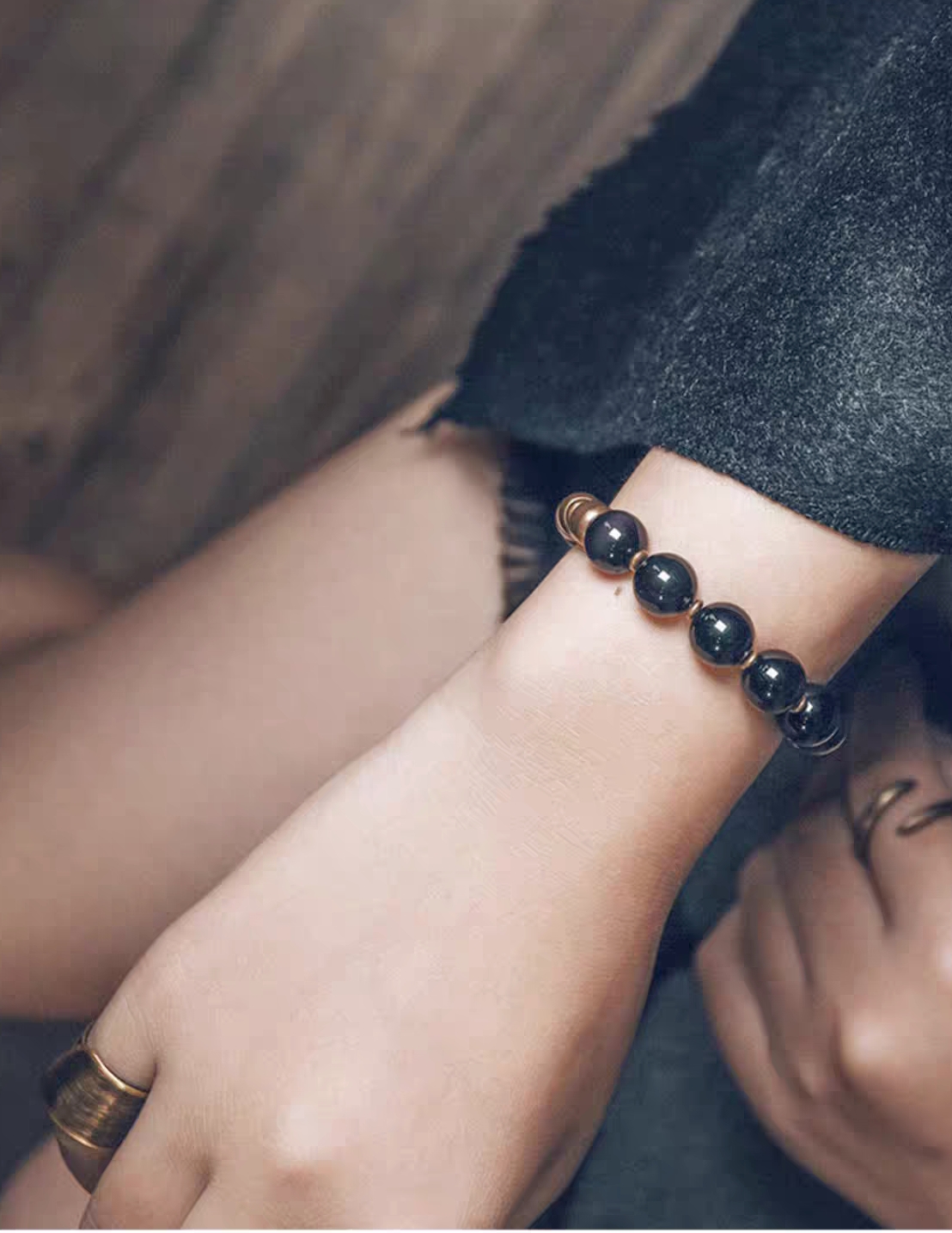Fu Mo Xuan Tong black obsidian and brass bracelet worn with dark layered clothing