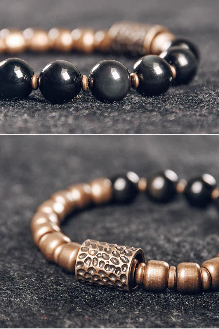 Close-up of glossy black obsidian beads and textured brass tube bead