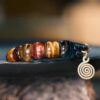 Close-up of multicolor tiger eye beads and brass spiral charm