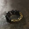 Style A faceted ebony wood bracelet with openwork brass knot links on white background