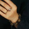 Close wrist view of the Style B ebony and square brass cage knot bracelet