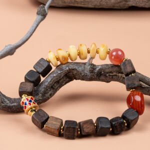 Agarwood, Amber & Red Agate Bracelet — bracelet with dark cube-shaped beads and pale discs around a branch