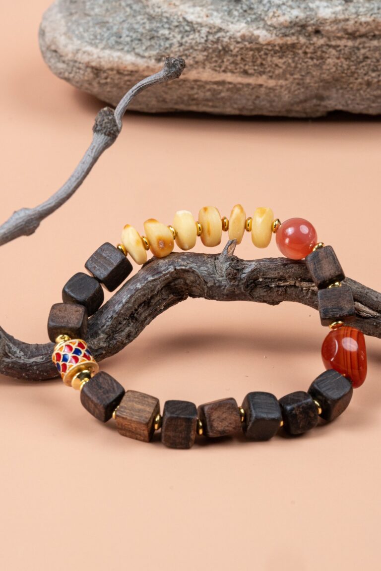 Agarwood, Amber & Red Agate Bracelet — bracelet with dark cube-shaped beads and pale discs around a branch