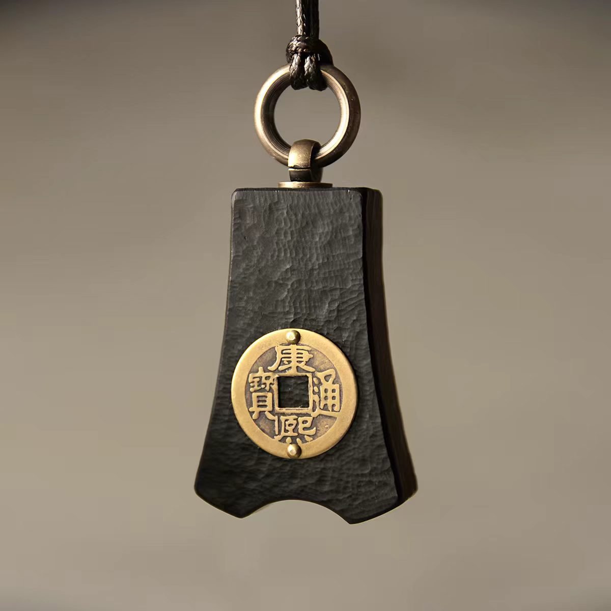 Bao Pu Qian (Embracing Simplicity Coin) Pendant — close view of one dark pendant with a coin motif