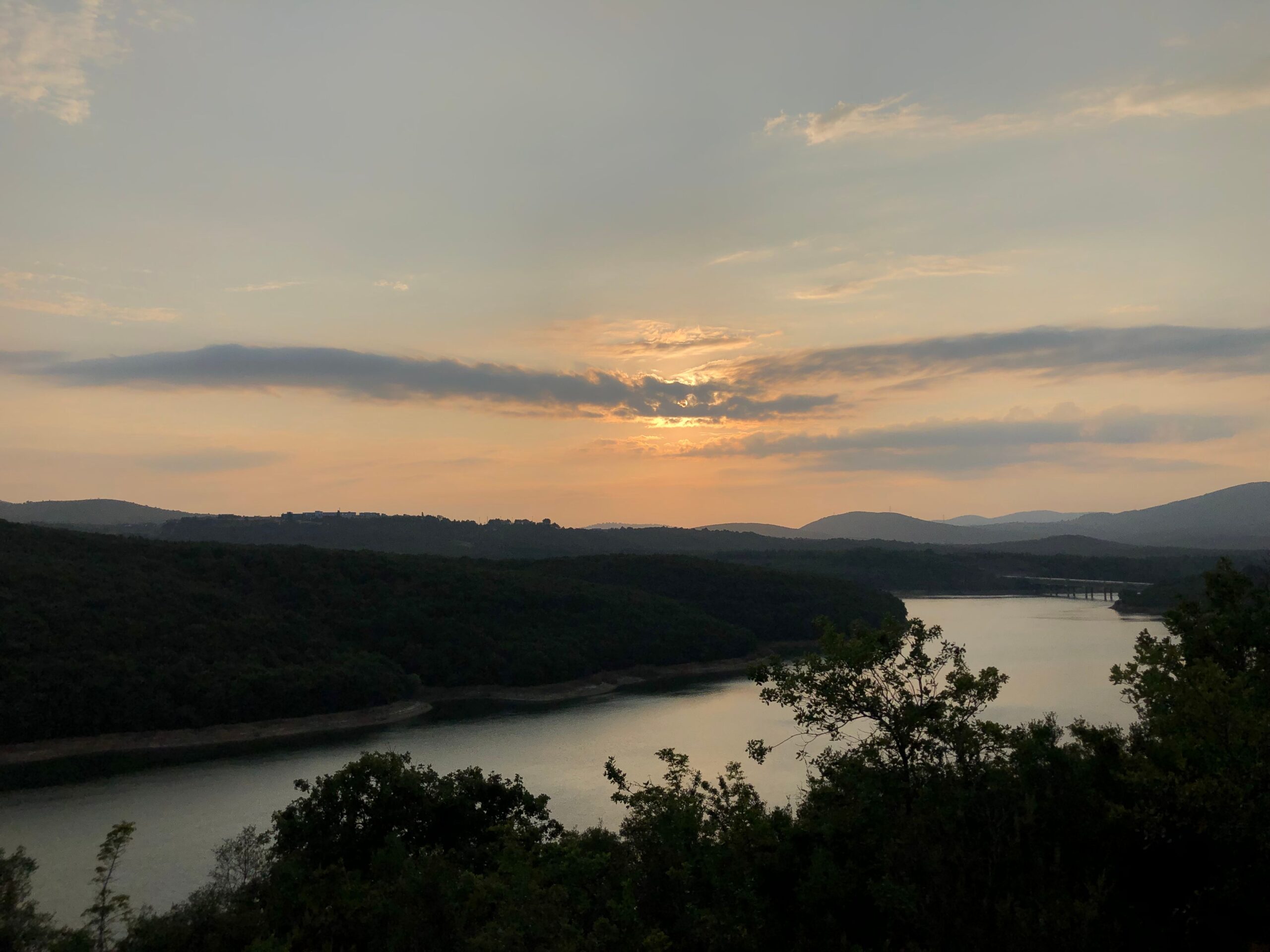 Sunset over a river bordered by trees