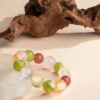 Chinese Zodiac Dragon Bracelet — multicolored bead bracelet beside wood and a pale display
