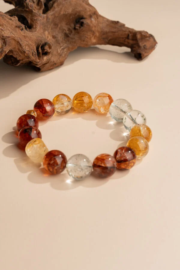 Chinese Zodiac Ox Bracelet — orange and red translucent bead bracelet beside wood