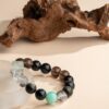 Chinese Zodiac Pig Bracelet — dark bead bracelet with a turquoise-colored accent on a pale support