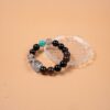 Chinese Zodiac Pig Bracelet — dark bead bracelet resting on a clear dish