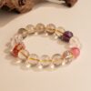 Chinese Zodiac Sheep Bracelet — pale bead bracelet with purple accents beside wood