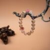 Chinese Zodiac Sheep Bracelet — pale bead bracelet hanging from a branch