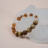 Chinese Zodiac Tiger Bracelet — gold-brown and clear bead bracelet against a pale display
