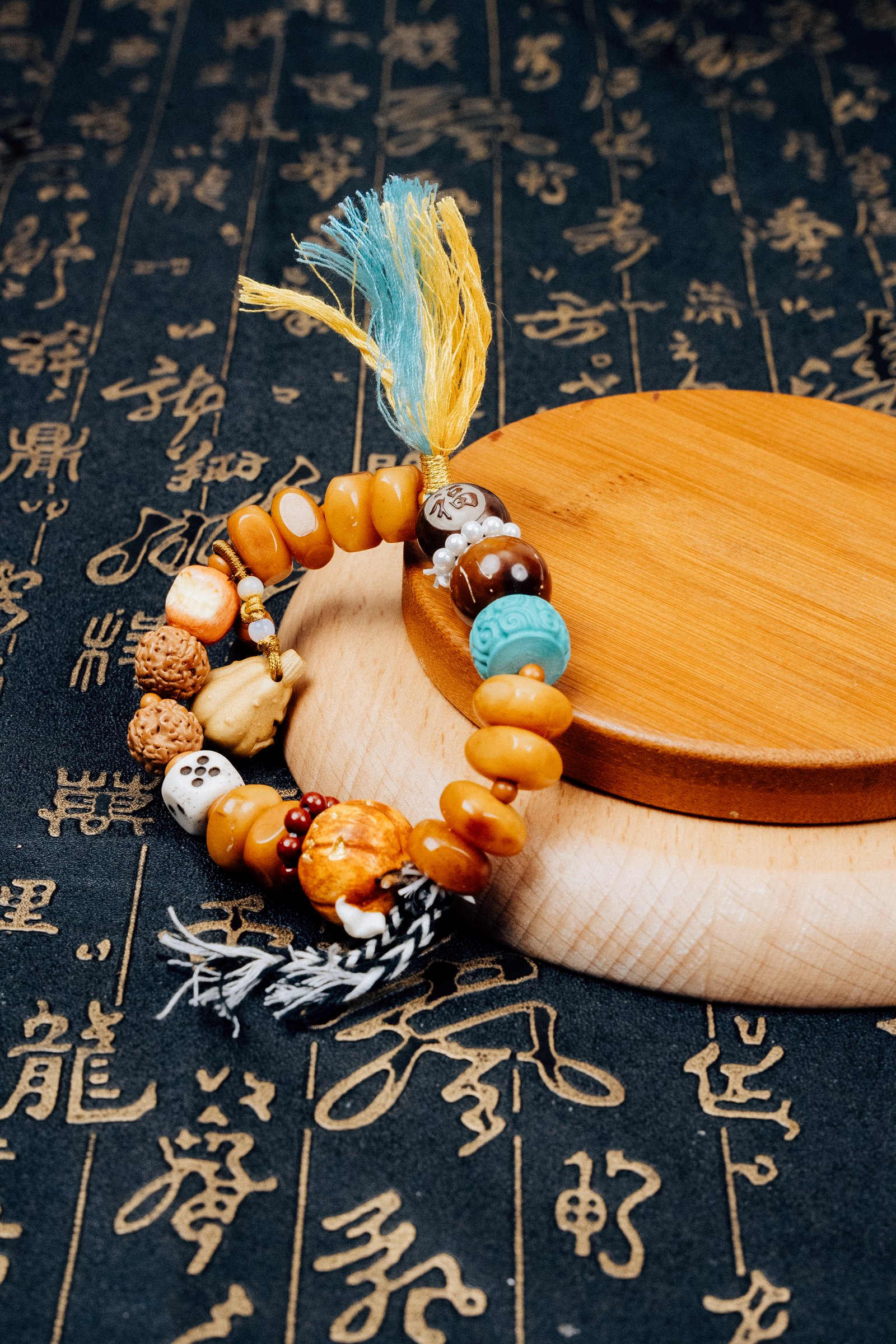 Fuling Agarwood & Bodhi Bead Bracelet — mixed-bead bracelet with tassels on a wooden display