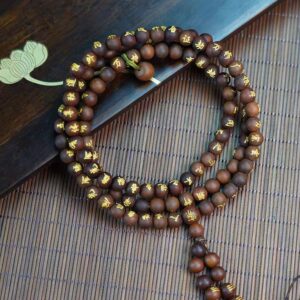 Golden Lightning Wood Taoist Prayer Beads — coiled dark bead strand with gold-colored inscriptions