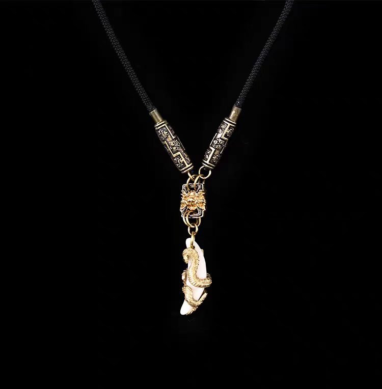 Golden Snake & Fang Pendant — pale curved pendant with gold-colored snake-shaped decoration
