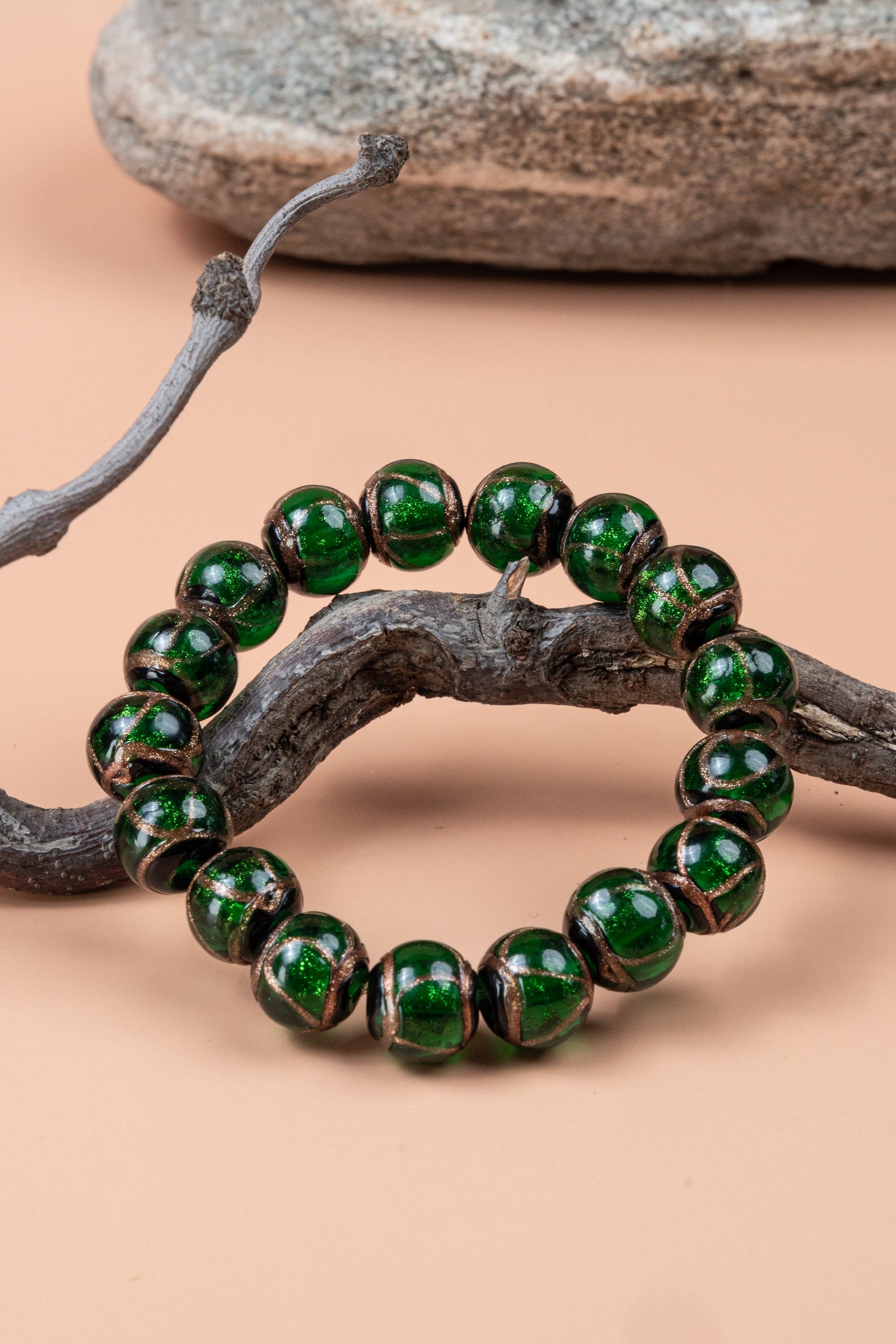 Green Incense Ash Liuli Bead Bracelet — green bead bracelet encircling a branch