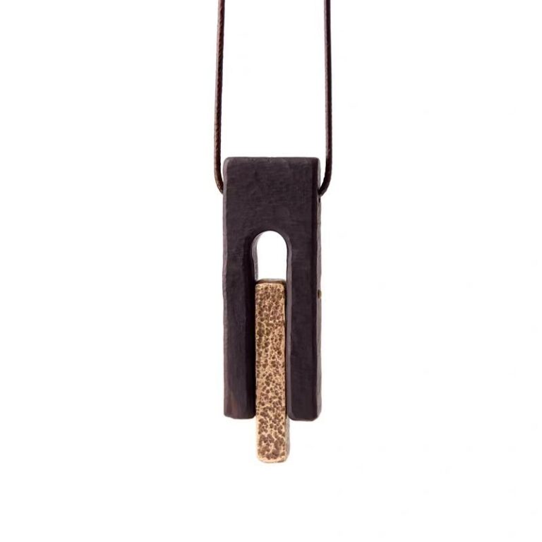 Gui Zhen(Returning to Simplicity) Pendant — dark fork-shaped pendant with a gold-colored inset on white