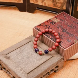 Huarui Furen Herbal Incense Bracelet — reddish bead bracelet beside a patterned box