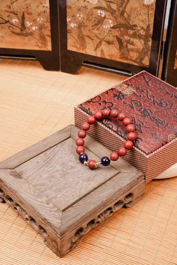 Huarui Furen Herbal Incense Bracelet — reddish bead bracelet beside a patterned box