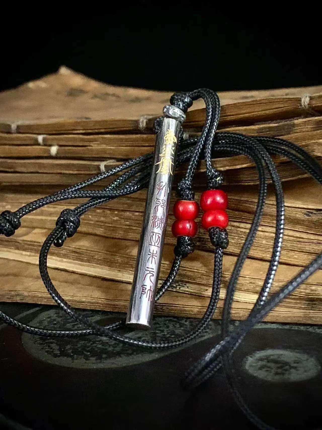 Kao Gui Rod 999 Silver Taoist Pendant — rod-shaped pendant with its cord coiled alongside