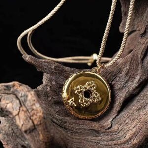Mountain Spirit's Verse Pendant — round pendant showing an ornate gold-colored face