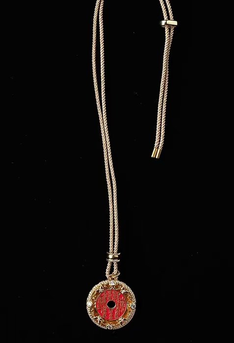 Mountain Spirit's Verse Pendant — round pendant hanging vertically against black