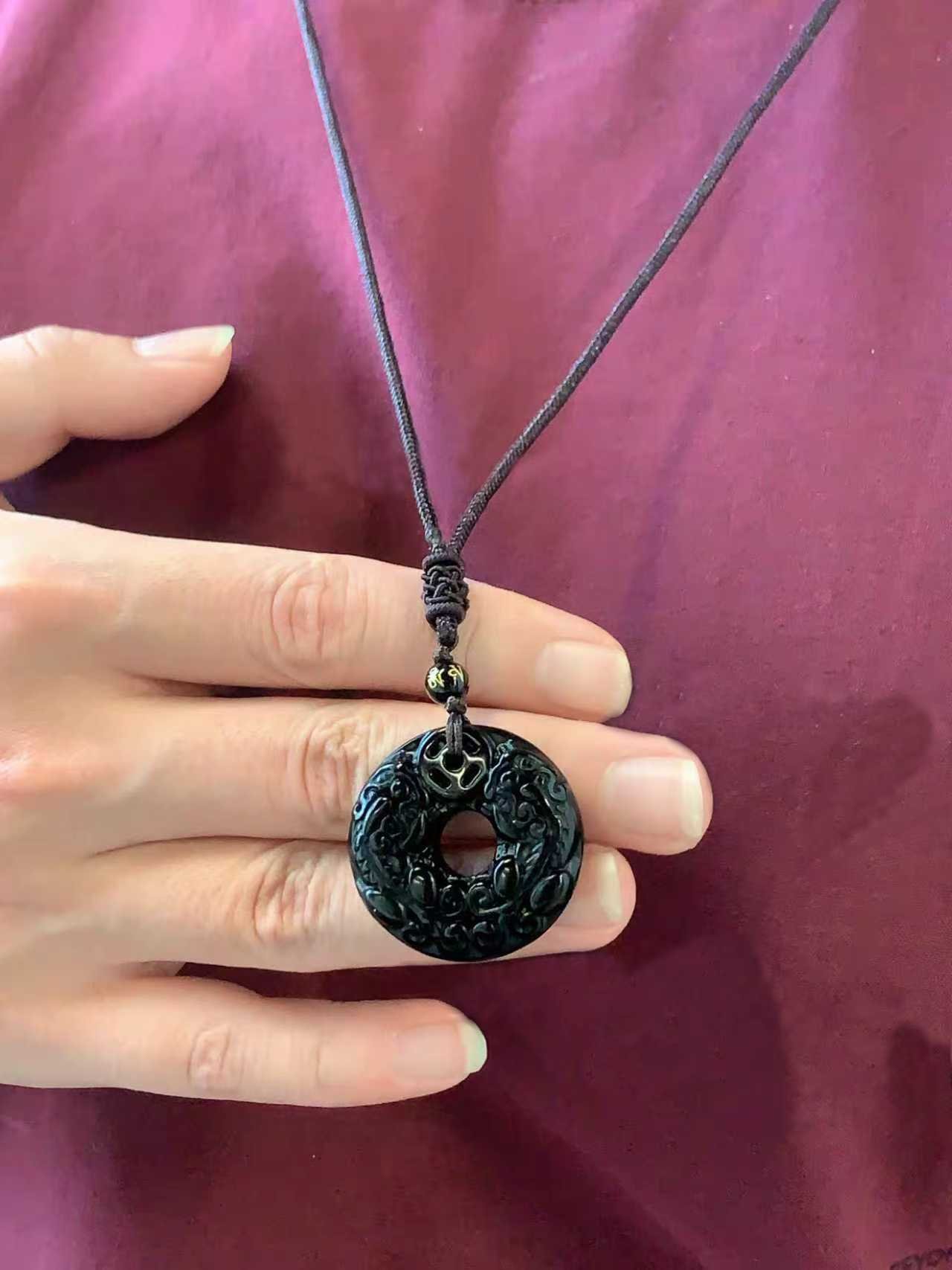 Pixiu Jade Pendant — dark carved pendant necklace held against clothing
