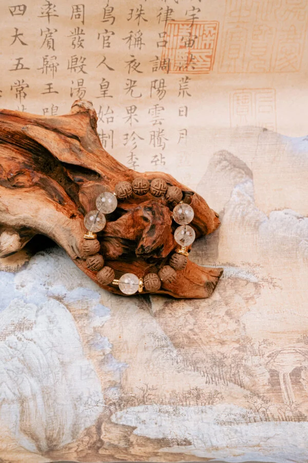 Qinglin Sui Super Seven Herbal Incense Bracelet — textured brown and translucent bead bracelet around wood