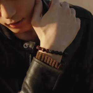 Red Tiger’s Eye & Silver Bracelet — faceted bead bracelet worn on a wrist with a dark sleeve