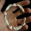 Thirty-Six Heavenly Generals 999 Silver Twisted Bracelet — twisted open cuff bracelet resting in a palm
