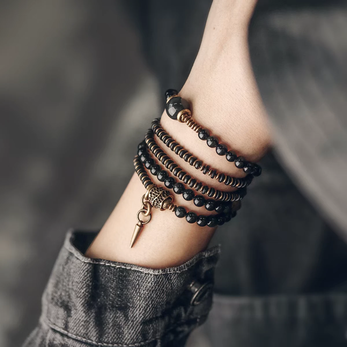 Vintage Floral Layered Obsidian Bracelet — layered bracelet worn on a wrist showing hanging charms