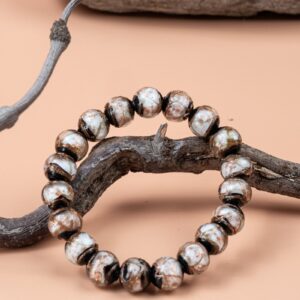 White Incense Ash Liuli Bead Bracelet — black and white patterned bead bracelet around a branch
