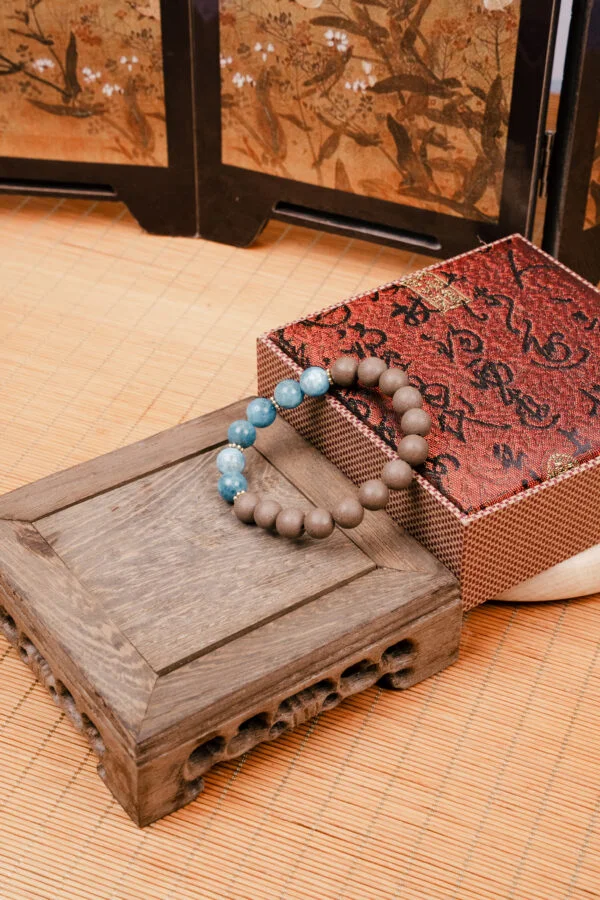 Wuzhen Herbal Incense Bracelet — brown and bright blue bead bracelet beside a patterned box