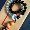 Black and pale beads with a yin-yang detail and small gourd-shaped pendant