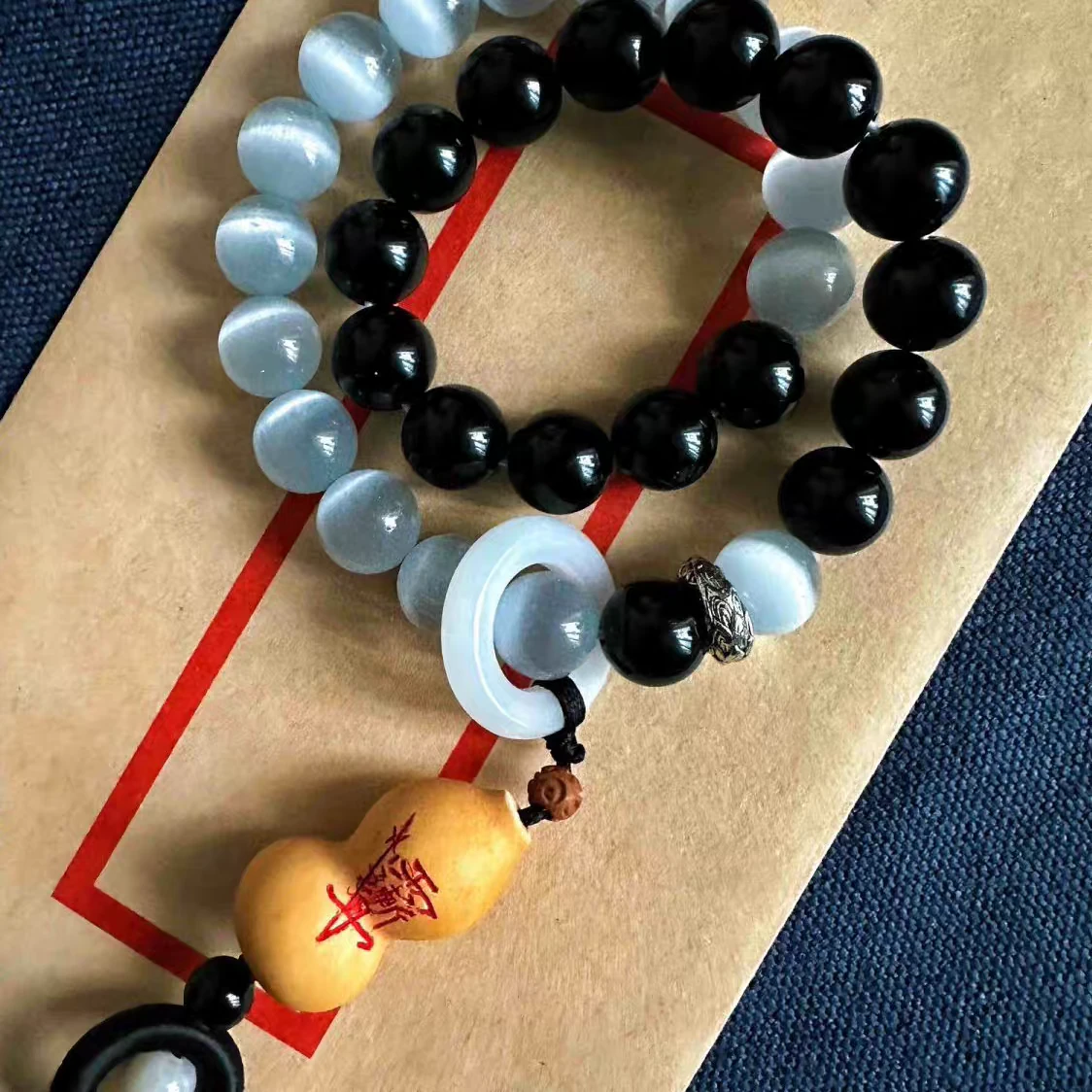 Black and pale beads with a yin-yang detail and small gourd-shaped pendant