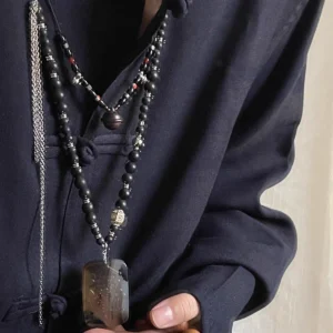 Zi Wei Ling Pendant — long dark bead necklace with pendant worn over dark clothing